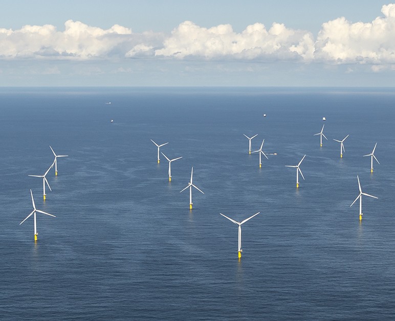 Aerial view of off shore windpark Luchterduinen. The windmills are in the Noordzee, 20 kilometers from the Dutch coastline between Noordwijk and Zandvoort. On the clear horizon a beautiful cloudstreet